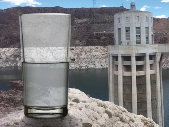 half glass of water in front of the hoover dam