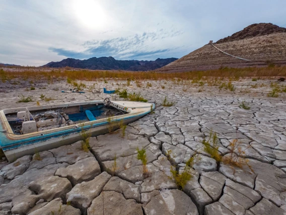 photo showing lake mead with boat on cracked earth