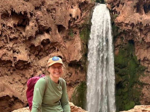 ashley hullinger sitting by a waterfall