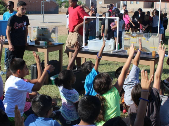 students raising hands to ask questions in an apw event