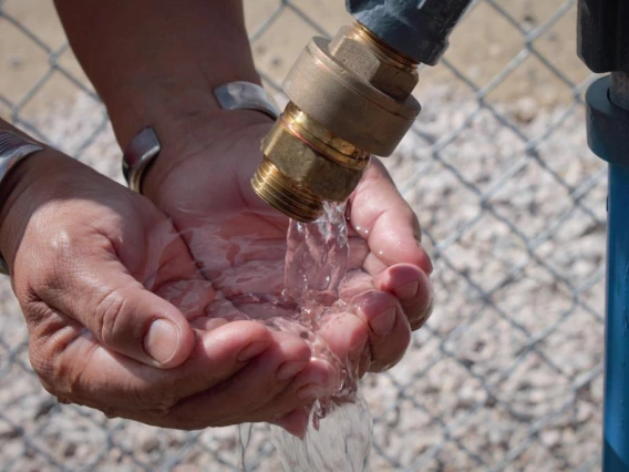 Cupped hands under running faucet