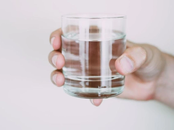 a hand holding a glass of water