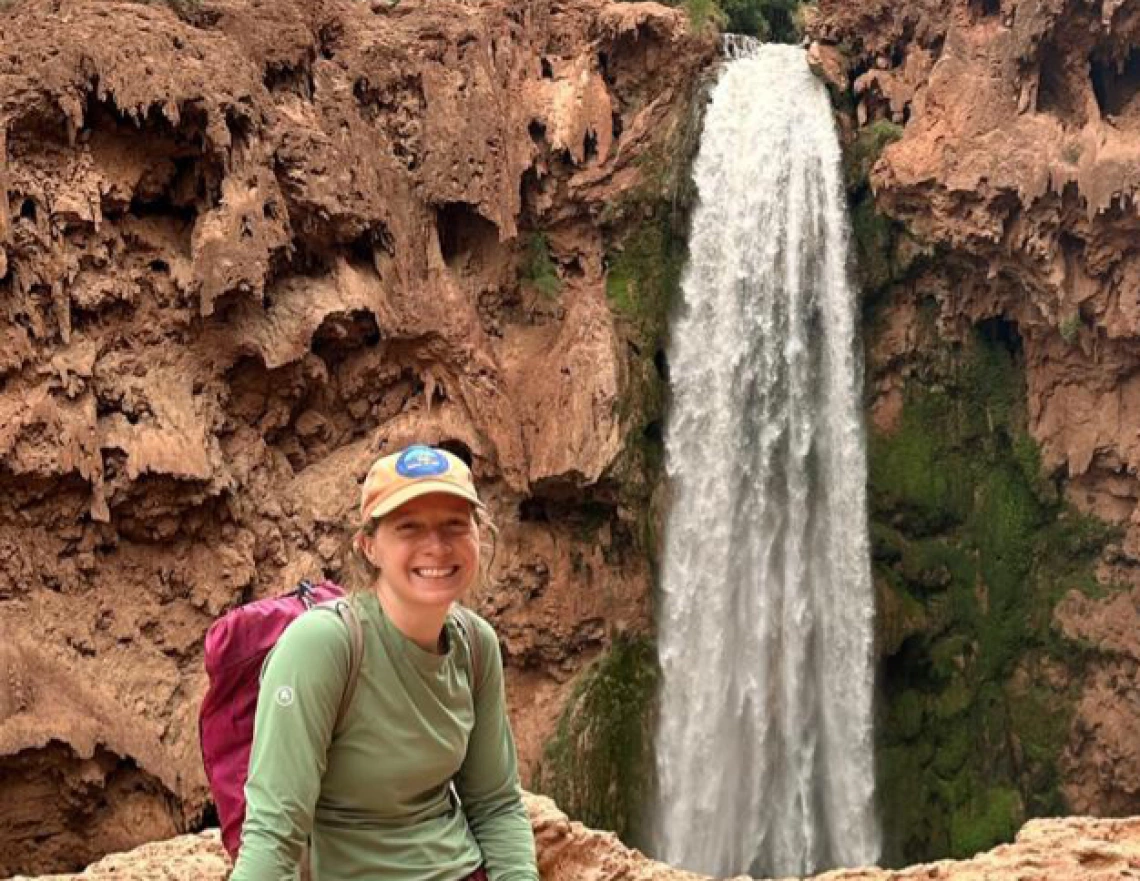 ashley hullinger sitting by a waterfall