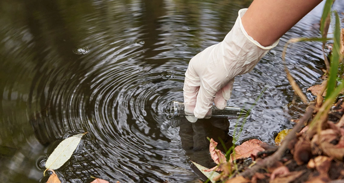 lead image of a scientist sampling water