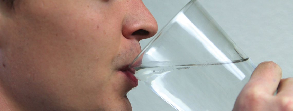 random guy drinking water out of a glass