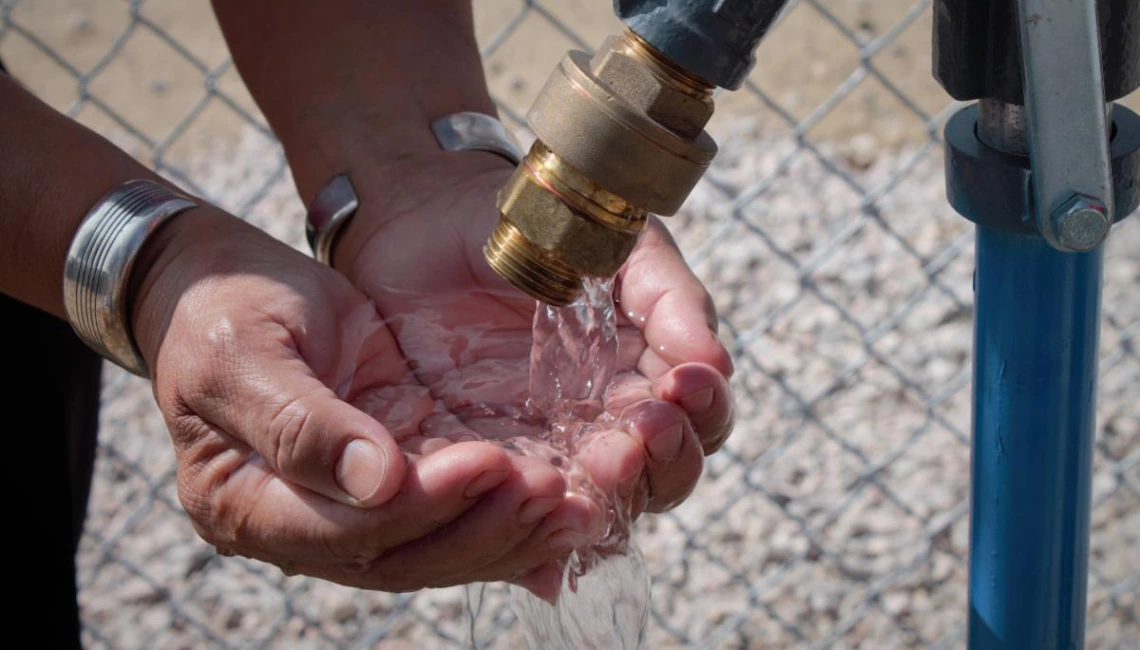 Cupped hands under running faucet